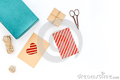 To wrap gift. Box, paper, envelope, thin cord, greeting card, ribbon, sciccors on white background top view copyspace Stock Photo