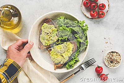 Toast with avocado, seeds served with green salad Stock Photo