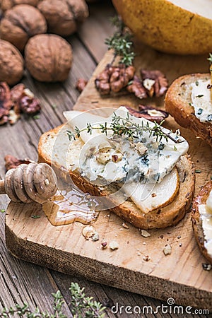 Toast or canape with goat cheese, thyme, honey, nuts. Delicious appetizer, ideal as an aperitif Stock Photo