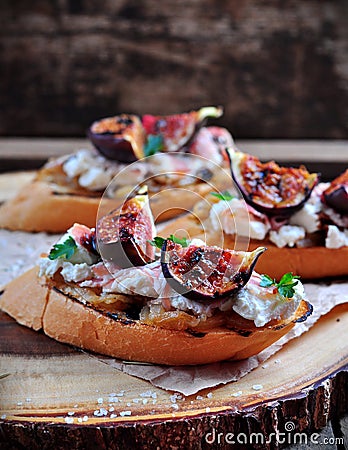 Toast with caramelized onions, goat cheese, jamon and grilled figs. selective focus Stock Photo
