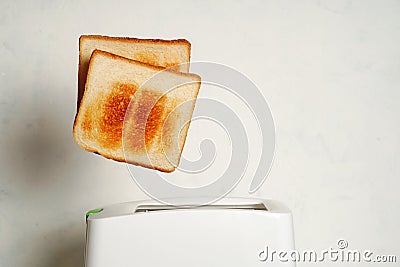 Toast pops out of the toaster, morning breakfast in the kitchen, fried bread health benefits Stock Photo