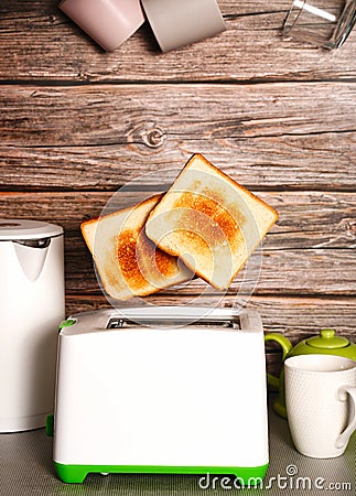 Toast pops out of the toaster, morning breakfast in the kitchen, fried bread health benefits Stock Photo