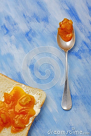 Toast slice with butter and jam and silver spoon with jam blob Stock Photo