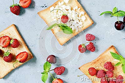 Toast with strawberries, raspberries, cherries, mint and cottage cheese for breakfast. Healthy breakfast, Ruddy bread toast. Stock Photo