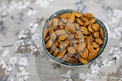 Toasted almonds on a bowl on a table with floral black and white decoration Stock Photo
