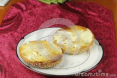 Toasted and Buttered Everything Bagel on a Plate Stock Photo
