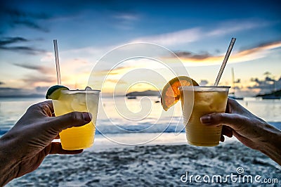 Toasting with tropical drinks on the beach. Stock Photo