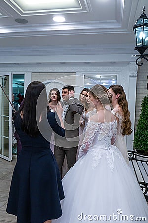 A toastmaster among bride models shows soomething Editorial Stock Photo