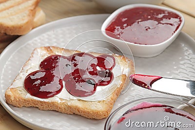 toasts with jam. fried crispy toast with red jam on a natural wooden table. breakfast Stock Photo