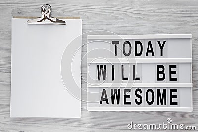 `Today will be awesome` words on modern board, noticepad over white wooden background, overhead view. Stock Photo