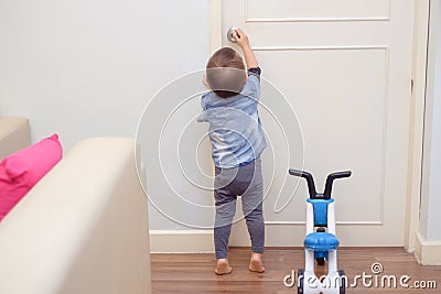 toddler baby boy standing on tiptoes at home Stock Photo