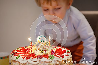 Toddler boy blowing candles on his 2 birthday cake Stock Photo