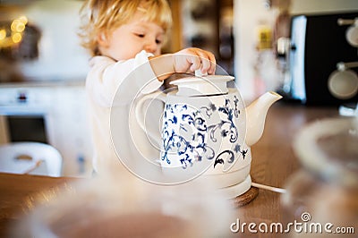 Toddler boy in dangerous situation at home. Child safety concept. Stock Photo