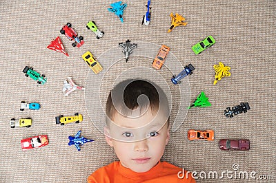 Toddler boy playing with car collection on carpet. Transportation,airplane, plane and helicopter toys for children Stock Photo