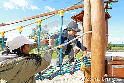 Toddler boy playing on playground - net bridge Stock Photo