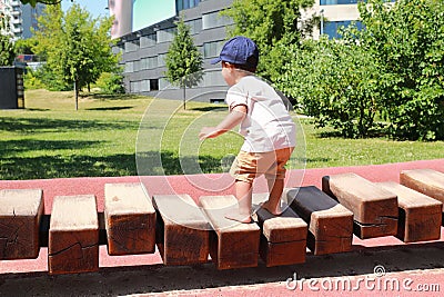Toddler boy playing on playground - unstable wooden bridge Stock Photo