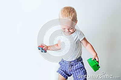 Toddler boy plays with constructor, cars, blocks close-up. Educational toys for preschool children Stock Photo
