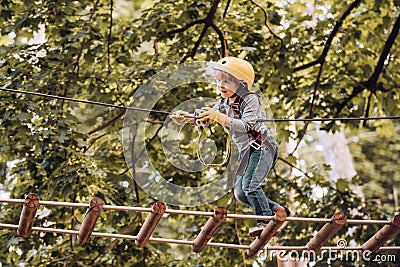 Toddler climbing in a rope playground structure. Children fun. Child concept. Safe Climbing extreme sport with helmet Stock Photo