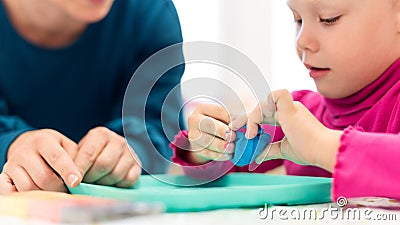 Toddler girl in child occupational therapy session doing sensory playful exercises with her therapist. Stock Photo