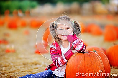 Toddler girl picking a pumpkin for Halloween Stock Photo