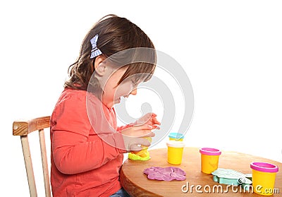 Toddler girl playing with play doh Stock Photo