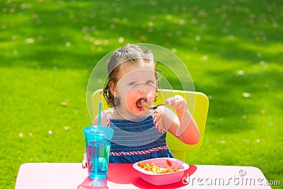 Toddler kid girl eating macaroni tomato pasta Stock Photo