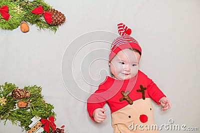 Toddler at the New Year`s carnival. disguised as a deer. The branches of a Christmas tree decorate it. Merry Cristmas. first Stock Photo