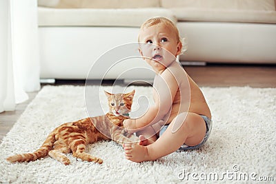 Toddler playing with cat Stock Photo