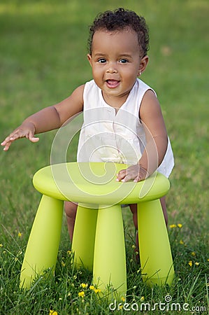 Toddler playing with chair Stock Photo