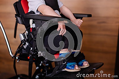 Beautiful boy child in a special wheelchair. Toddler with cerebral palsy Stock Photo