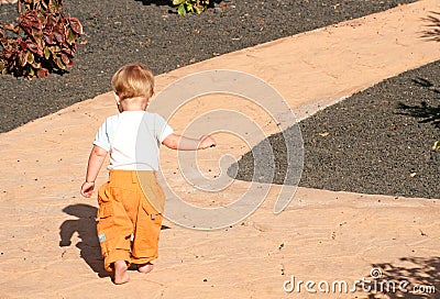 Toddler walking along path Stock Photo