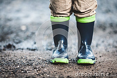 Toddler wearing rubber boots in rainy weather Stock Photo