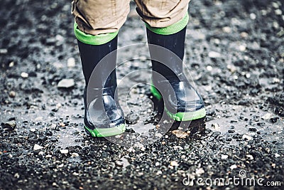 Toddler wearing rubber boots in rainy weather Stock Photo