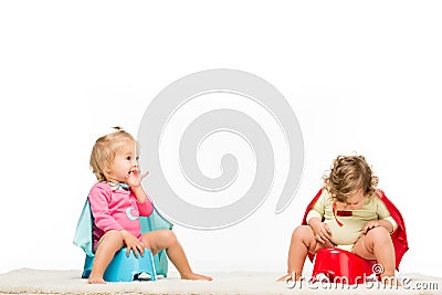 toddlers sitting on potties Stock Photo