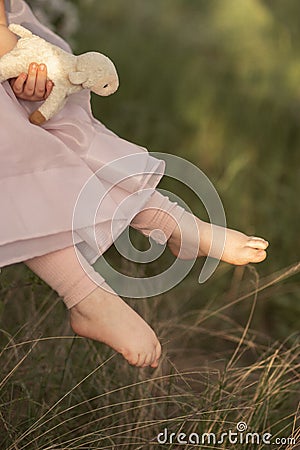 todler girl is holding the lamb toy Stock Photo