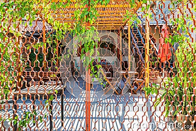 A restaurant courtyard seen through a metal fence Editorial Stock Photo