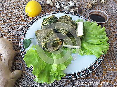 Tofu in green nettles tempura, on a plate with lettuce Stock Photo