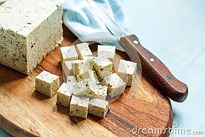 Tofu sliced on a wooden board. Stock Photo