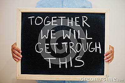 Together we will get trough this. Coronavirus concept. Boy hold inscription on the board Stock Photo