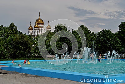 View of the fountain in Zhilkin square on a hot sunny day and children bathing in it. Editorial Stock Photo
