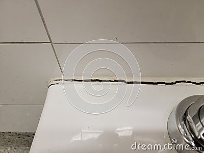 toilet in bathroom with crack in the wall or caulk Stock Photo