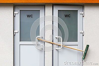 Toilet doors are closed with a broom. Public toilet is not working. Stock Photo