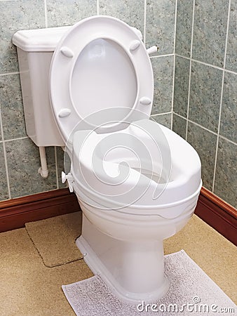 Toilet with height extension for disabled senior person indoors in house Stock Photo