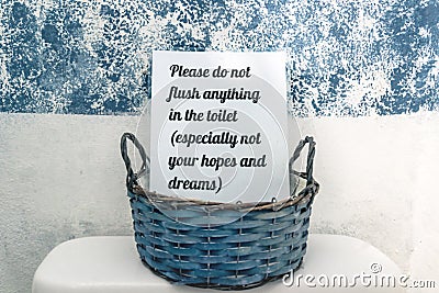 Toilet sign in basket with text `Please do not flush anything in the toilet - especially not your hope and dreams Stock Photo