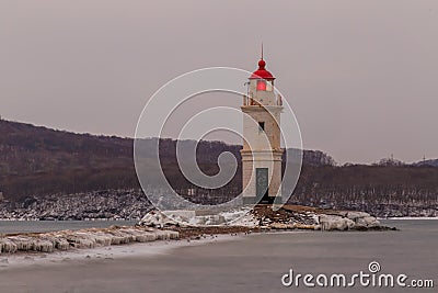 Tokarevsky lighthouse during a colorful dawn against the backdrop of a beautiful sea. Stock Photo