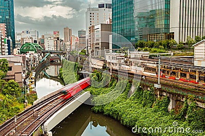 TOKYO, JAPAN - AUGUST 09 2023: Long exposure image of subway and rail trains passing over the Kanda River at the Editorial Stock Photo