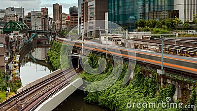 TOKYO, JAPAN - AUGUST 09 2023: Long exposure image of subway and rail trains passing over the Kanda River at the Editorial Stock Photo