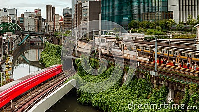 TOKYO, JAPAN - AUGUST 09 2023: Long exposure image of subway and rail trains passing over the Kanda River at the Editorial Stock Photo