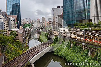 TOKYO, JAPAN - AUGUST 09 2023: Trains passing a busy intersection and tunnel over the Kanda River at the Hijiribashi Bridge, Tokyo Editorial Stock Photo