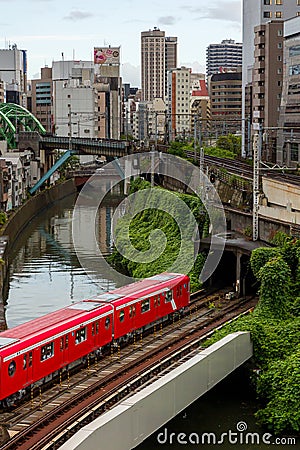 TOKYO, JAPAN - AUGUST 09 2023: Trains passing a busy intersection and tunnel over the Kanda River at the Hijiribashi Bridge, Tokyo Editorial Stock Photo